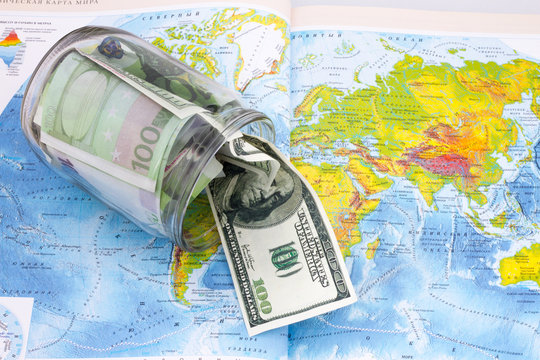 glass jar with dollars on the world map
