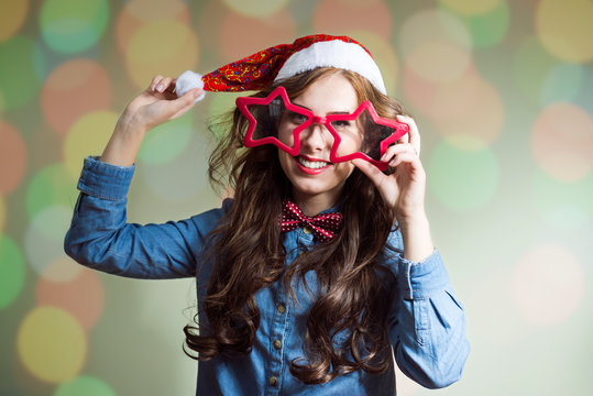 Happy hipster in supersize star shaped glasses and santa hat