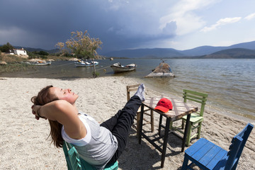 Woman is resting at characteristic restaurant on coast of the lake