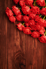 Obraz premium red roses over wooden brown background