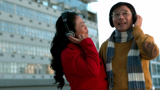 Couple in warm clothes enjoying music together
