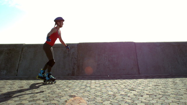 Happy sporty woman inline skating