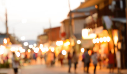 Blurred crowd walking on the street, night market - can be used as abstract blur background