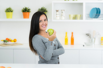 Nettes Mädchen in Küche mit Apfel