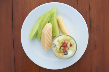 Soy custard in fresh milk in glass and cantaloupe on wooden table