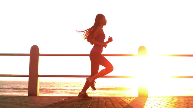 Sporty woman jogging with sunset