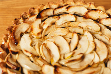 homemade delicious traditional apple pie with caramel on a plate on wood table and white background