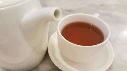 hot tea in the cup and tea pot