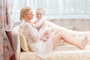 Mother and baby playing and smiling. Happy family.Home interior.