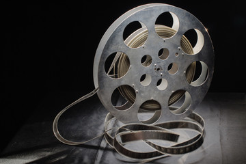 reel of film standing on a black table