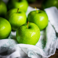 Bright green apples on wooden background
