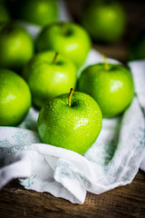 Bright green apples on wooden background