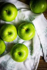Bright green apples on wooden background