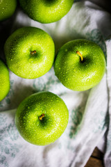 Bright green apples on wooden background