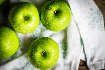 Bright green apples on wooden background
