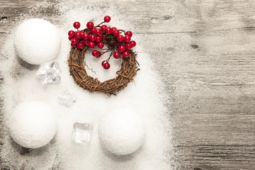 Christmas card with snowballs and snow and Christmas wreaths on the wooden background.