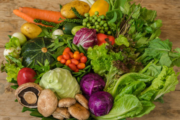 Close up of various colorful raw vegetables in banana leaf basket.