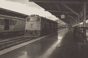 Perspective of train, Diesel locomotive while it moving, on Bangkok railway station platform Thailand, black and white, vintage effect