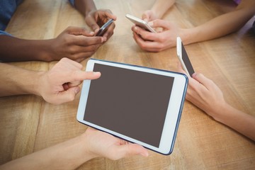 High angle view of cropped hand pointing at digital tablet 