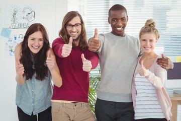 Portrait of smiling business team with thumbs up