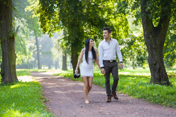 young couple taking a walk through the park