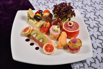 Antipasto and catering platter with different appetizers (fruits