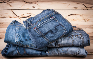 fashionable clothes. pile of jeans on a wooden background