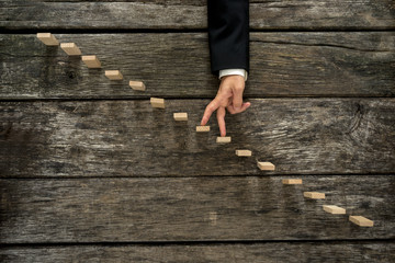 Businessman walking his fingers up steps