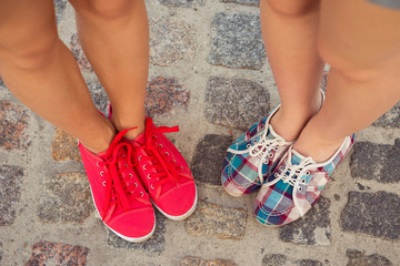 top view of a two pairs of sneakers shoes walking on paving ston