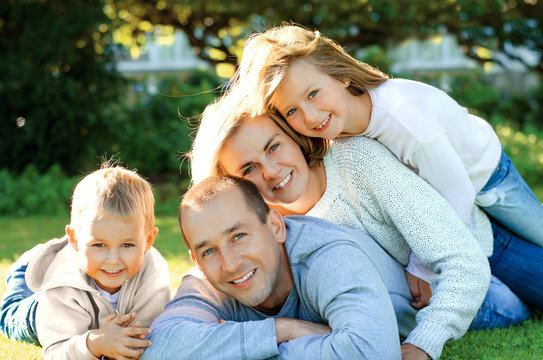 Family lying on the grass and smiling
