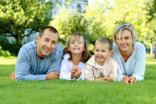 Family lying on the grass and smiling