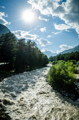 The sun shining over the mountain river