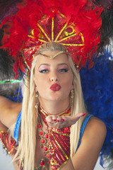 Woman samba dancer blowing a kiss towards the camera.