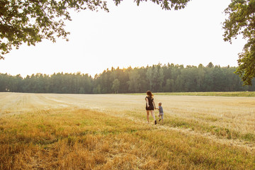 Mother with child walking across the field
