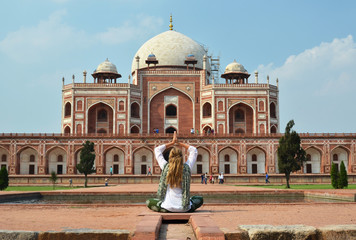 Young woman meditating in the yard of Humayun's Tomb. Delhi, Ind