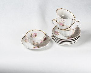 Antique porcelain tea cups with floral painting on white backgro