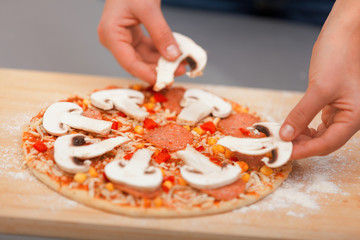 Obraz na płótnie Canvas Young woman preparing pizza