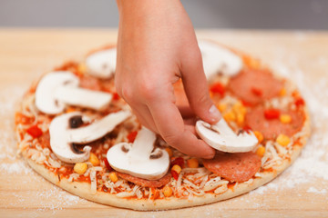 Obraz na płótnie Canvas Young woman preparing pizza