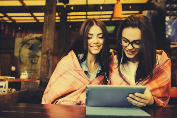 two close friends watching something on a tablet