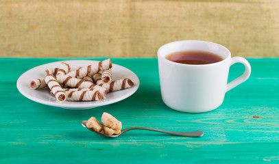 Tubules wafer and tea with a lemon on an old table