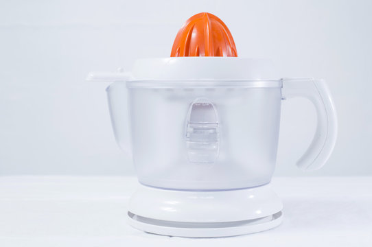 M&aacute;quina exprimidor de jugo de naranja sobre fondo gris 