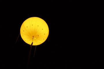 Erleuchteter gelber Ballon vor Nachthimmel