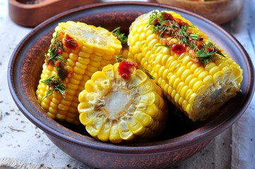 boiled corn with hot tomato sauce, herbs, salt and spices