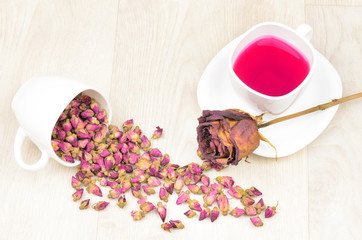 tea roses scattered, hot tea and dried rose flower on wooden tab