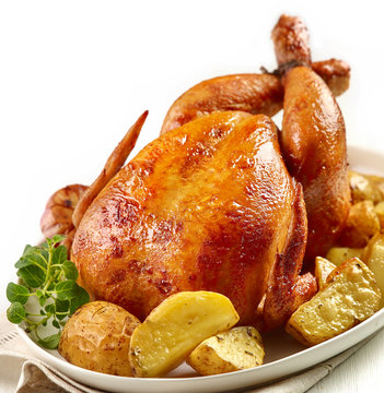 roasted chicken with potatoes on white plate