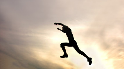 Fototapeta na wymiar silhouette of jumping boy against sky