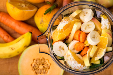 Looking down at fresh cut fruit and vegetables in a blender