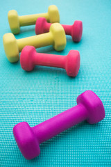 Dumbbells Scattered on a Blue Yoga Mat