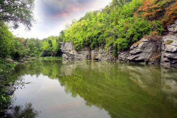 Fototapeta premium Rocks over river in green forest