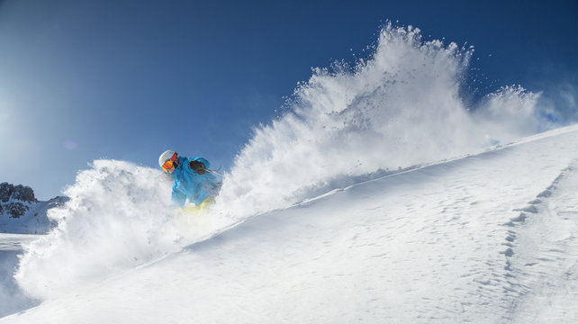 Skier skiing downhill in high mountains